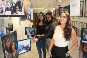 A imagem mostra três mulheres no ambiente do Memorial da Justiça Militar. Elas observam uma exposição composta por textos e fotos diversos.