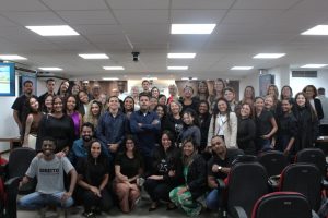 A imagem mostra um grupo de 49 pessoas, entre homens e mulheres, reunidas no Tribunal Pleno. A maioria está em pé e algumas estão agachadas na parte da frente.